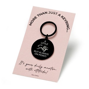 Peut inclure: Porte-clés en métal noir avec une étiquette ronde qui dit "A Little Satty But Always On Point!" C'est votre mantra quotidien avec attitude ! Bijou Betty.