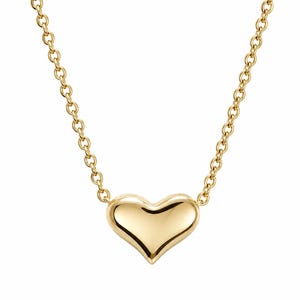 K&ouml;nnte beinhalten: Eine goldfarbene Halskette mit einem herzf&ouml;rmigen Anh&auml;nger. Der Anh&auml;nger ist glatt und poliert, mit einer abgerundeten Form. Die Kette ist filigran und besteht aus kleinen, verbundenen Kreisen. Die Halskette wird vor wei&szlig;em Hintergrund pr&auml;sentiert.