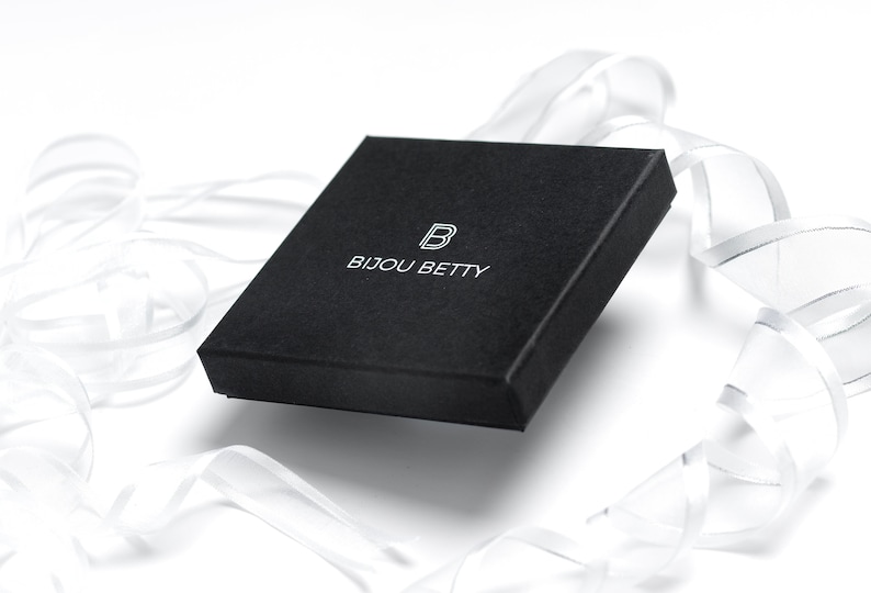May include: A black square box with the text "BIJOU BETTY" and a stylized "B" logo printed in white.