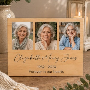 May include: A rectangular light-coloured wooden memorial plaque featuring three square photo inserts of a woman with grey hair. The text reads Elizabeth Mary Jones, 1952-2024, and Forever in our hearts in black script and sans-serif fonts.