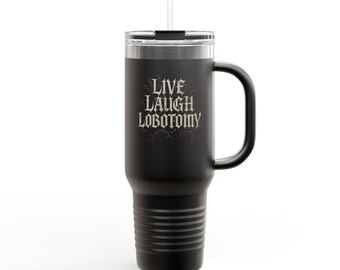 May include: Black insulated tumbler with a handle and a straw. The tumbler features the text "LIVE LAUGH LOBOTOMY" in a gothic font. The tumbler has a silver rim and a black handle. The tumbler is designed to hold approximately 30 ounces.