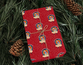 May include: Red wrapping paper with a repeating pattern of a person inside a rainbow circle. The text "This is the ass of a new era" is printed around the circle. The paper is tied with twine and set against a background of pine needles and pine cones.