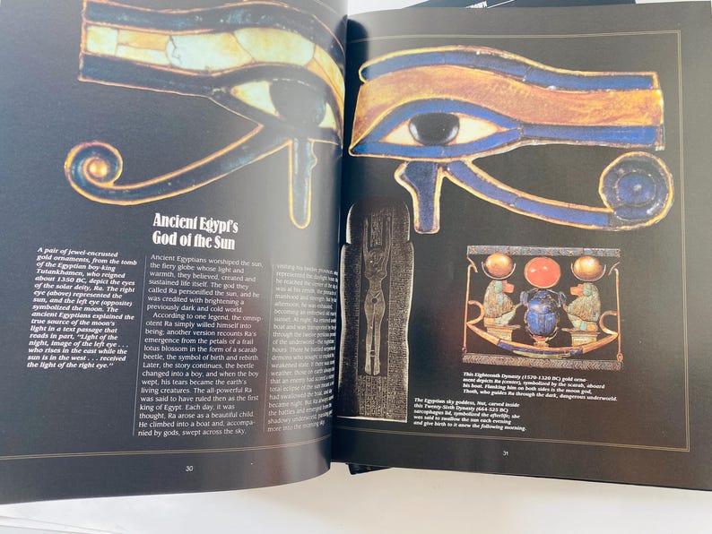May include: Open book page featuring illustrations of ancient Egyptian artifacts. The page displays a detailed depiction of the Eye of Horus, with blue, gold, and black colors. Text on the page describes the God of the Sun and the significance of the eye.