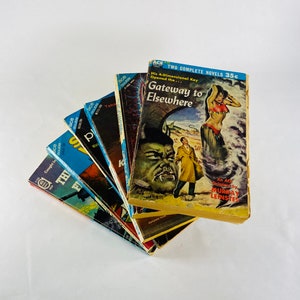 May include: A stack of vintage paperback books with colorful covers. The top book is titled "Gateway to Elsewhere" and features a woman in a red and blue costume and a man in a brown suit. The book is by Murray Leinster.