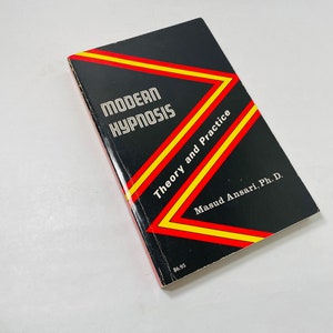 May include: A black book with a yellow and red striped design on the cover. The title is "Modern Hypnosis Theory and Practice" by Masud Ansari, Ph.D.