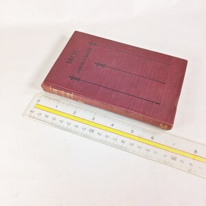 May include: A burgundy hardback book with the title "MOI" and the text "LABICHE ET MARTIN" on the spine. The book is lying on a white surface with a ruler next to it.