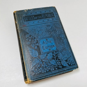 May include: A blue book titled "Battles of the Republic" with an ornate floral design on the cover. The book is a "Alta Edition".