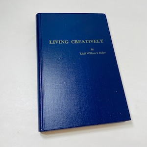 May include: A navy blue hardcover book titled "Living Creatively" by Rabbi William S. Malev.