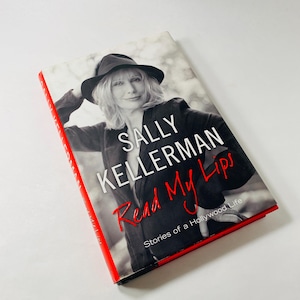 Könnte beinhalten: Ein Buch mit dem Titel "Read My Lips: Stories of a Hollywood Life" von Sally Kellerman. Der Umschlag zeigt ein Schwarzweißfoto von Sally Kellerman mit Hut.