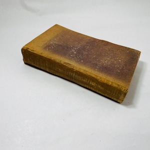 May include: A vintage, brown, hardback book with a worn cover.