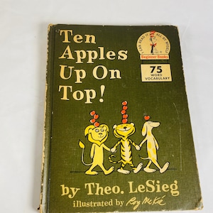 May include: A green book cover with the title "Ten Apples Up On Top!" by Theo. LeSieg, illustrated by Roy McKie. The book is part of the Beginner Books series and features a 75-word vocabulary.