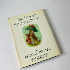 Könnte beinhalten: Ein Vintage-Exemplar von "The Tale of Benjamin Bunny" von Beatrix Potter. Das Buchcover zeigt eine Illustration eines Hasen mit Hut und rotem Tuch. Titel und Autorenname sind in Grün und Schwarz gedruckt.