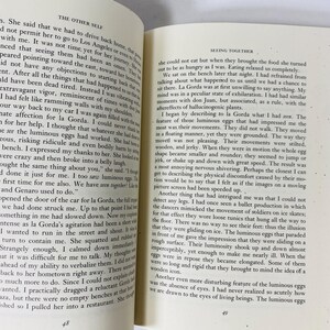 Op de afbeelding: Open boek met tekst op de pagina's. De tekst is in zwarte letters op een cr&egrave;mekleurige achtergrond. Het boek is opengevallen op twee pagina's, waarbij de tekst de pagina's vult. Het boek heeft een donkerblauwe kaft.