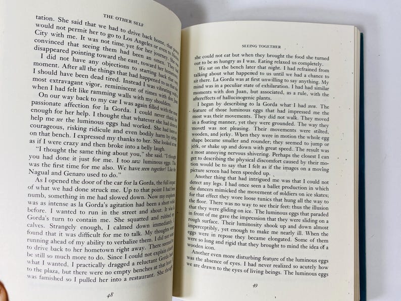 Op de afbeelding: Open boek met tekst op de pagina's. De tekst is in zwarte letters op een cr&egrave;mekleurige achtergrond. Het boek is opengevallen op twee pagina's, waarbij de tekst de pagina's vult. Het boek heeft een donkerblauwe kaft.