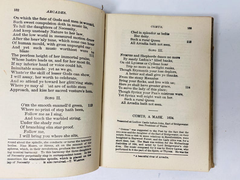 May include: Open book pages with antique text. The left page features the title "ARCADES" and poetry. The right page displays "COMUS" and more text. The pages are aged with visible wear and tear.