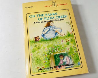 On the Banks of Plum Creek vintage paperback book circa 1971 by Laura Ingalls Wilder part of Little House on the Prairie series.