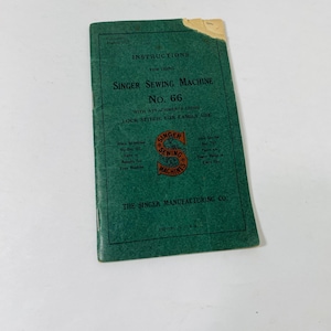 May include: Green instruction booklet for a Singer Sewing Machine No. 66 with attachments 320380. The booklet has the text "Lock Stitch, for Family Use" and a red and white Singer Sewing Machines logo.