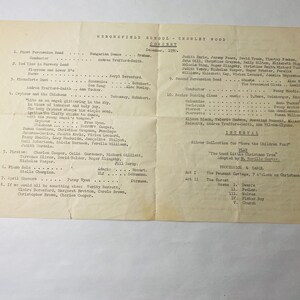 Puede incluir: Un programa en blanco y negro para un concierto escolar que presenta una lista de actuaciones musicales, incluyendo una banda de percusión, un coro y una obra de teatro. El concierto está programado para diciembre de 1959.