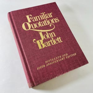 Könnte beinhalten: Ein weinrotes Hardcover-Buch mit dem Titel "Familiar Quotations" von John Bartlett. Titel und Autorenname sind in goldener Schrift gehalten. Es ist die fünfzehnte und 125-jährige Jubiläumsausgabe.