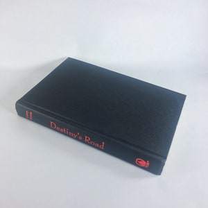 May include: A black hardcover book with the title "Destiny's Road" in red lettering on the spine. The book is by author Larry Niven.