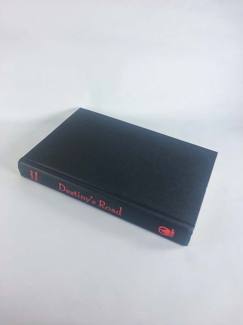 May include: A black hardcover book with the title "Destiny's Road" in red lettering on the spine. The book is by author Larry Niven.