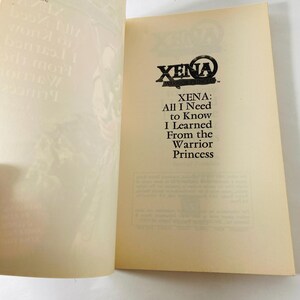 Pu&ograve; includere: Un libro con copertina flessibile intitolato Xena: All I Need to Know I Learned From the Warrior Princess. La pagina aperta mostra il titolo in testo nero su uno sfondo color crema, con un codice a barre visibile nell'angolo in alto a sinistra.