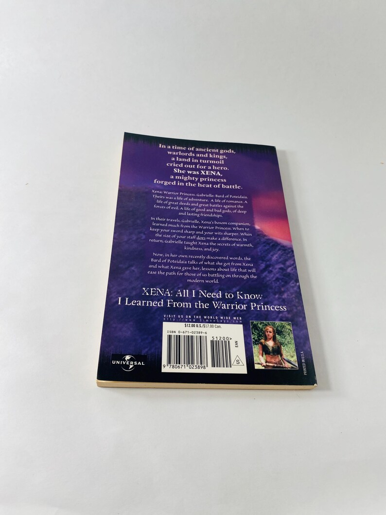 Pu&ograve; includere: Un libro tascabile intitolato Xena: All I Need to Know I Learned From the Warrior Princess. La quarta di copertina presenta uno sfondo viola con testo bianco, una piccola fotografia di una donna, un codice a barre e il logo Universal.