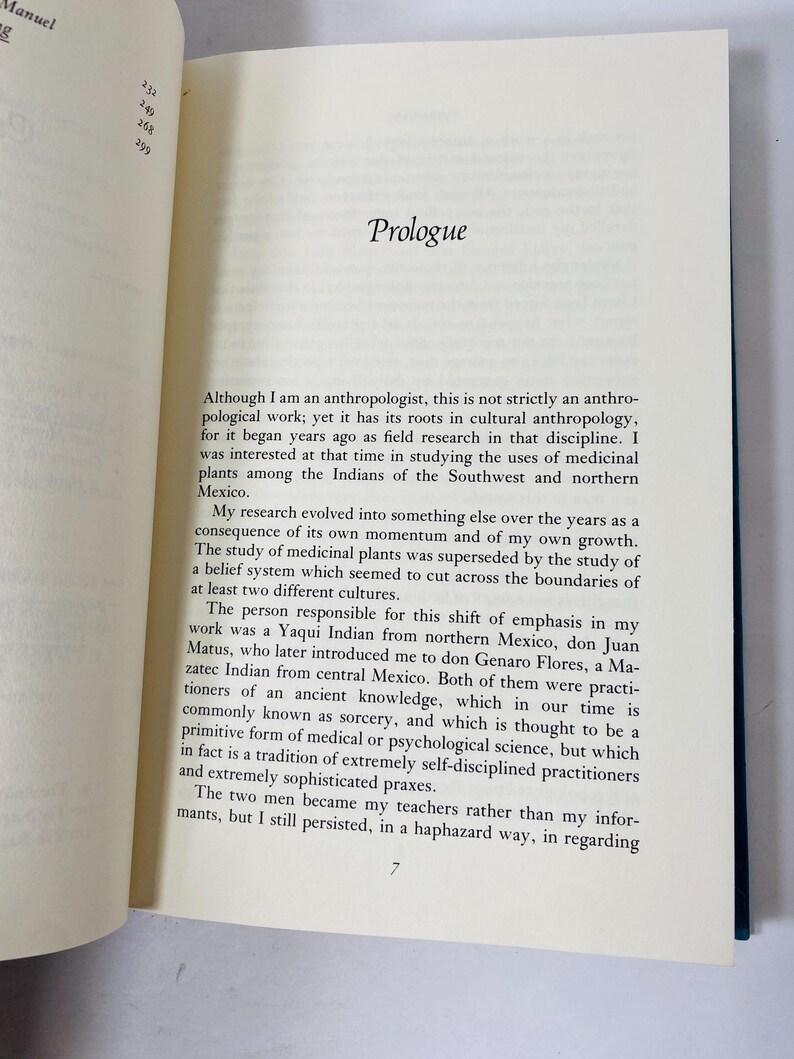 Op de afbeelding: Open boek met tekst op de pagina's. Het woord "Prologue" staat bovenaan de pagina. De tekst is in zwarte letters. Het boek heeft een blauwe kaft.