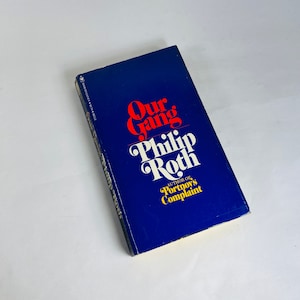 May include: A blue hardcover book titled "Our Gang" by Philip Roth, author of "Portnoy's Complaint".