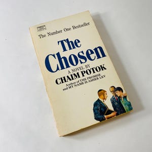 May include: A paperback book titled The Chosen by Chaim Potok with a cream-colored cover. The text reads The Number One Bestseller, A Novel By Chaim Potok, and Author of The Promise and My Name Is Asher Lev. An illustration shows three men.