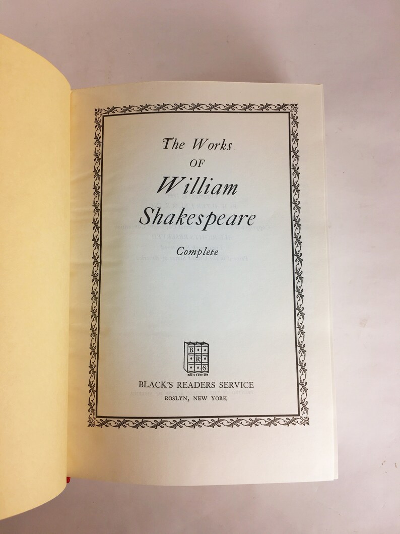 May include: Open book with the title "The Works of William Shakespeare" in a decorative frame. The book is from Black's Readers Service, Roslyn, New York. The pages are off-white with a red bookmark.