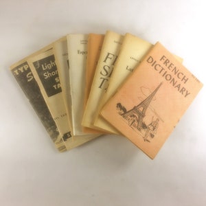 May include: A collection of seven small paperback books with various titles, including "French Dictionary", "First Steps in French", "Esperanto", "Light Short Stories", and "TYP S". The books are arranged in a fan shape with the covers facing outward.
