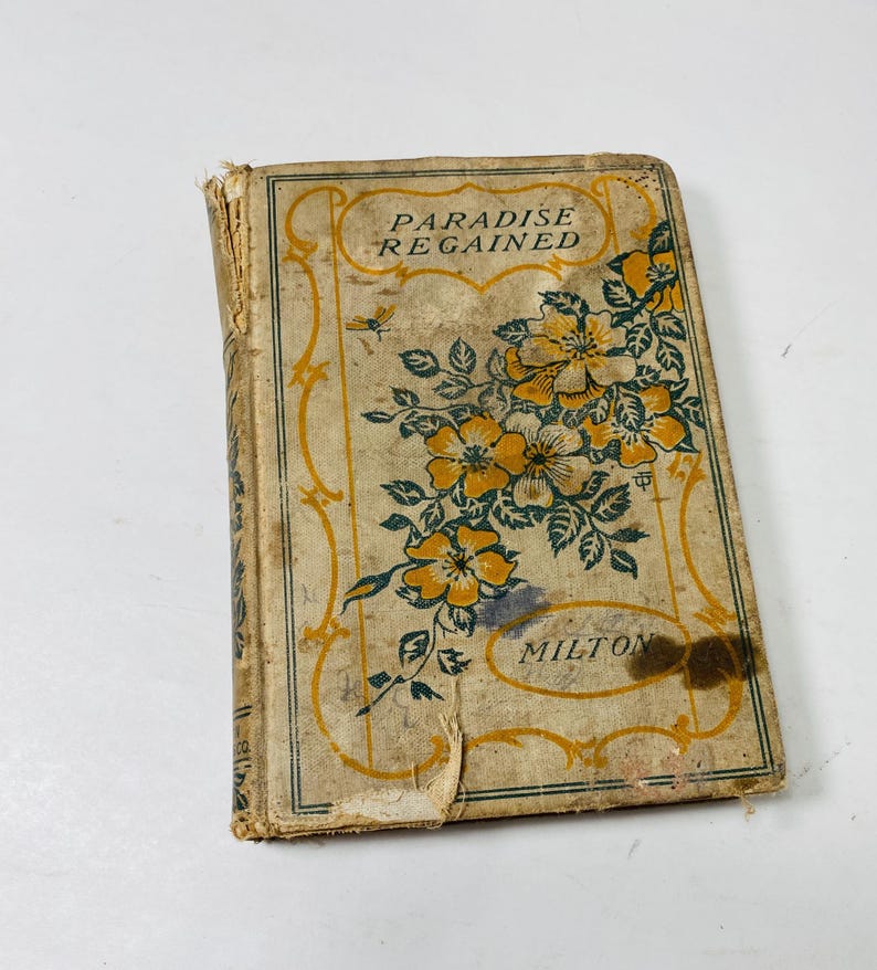 May include: Vintage book titled "Paradise Regained" by Milton. The cover features a floral design with yellow and green flowers on a beige background. The book shows signs of wear and age.