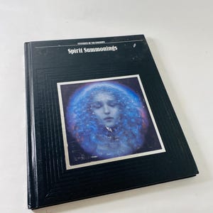 May include: A black hardcover book titled "Spirit Summonings" with a blue and white image of a person on the cover. The book is part of the "Mysteries of the Unknown" series.