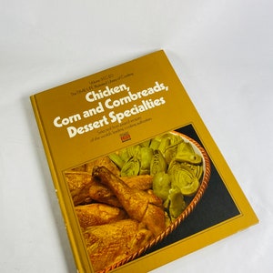 May include: A yellow cookbook titled "Chicken, Corn and Cornbreads, Dessert Specialties" from the TIME-LIFE Illustrated Library of Cooking. The cover features a photograph of roasted chicken and artichoke hearts in a wicker basket.