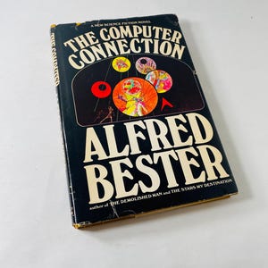 May include: A vintage paperback book titled "The Computer Connection" by Alfred Bester. The cover is black with white lettering and colorful abstract graphics. The book is a science fiction novel.