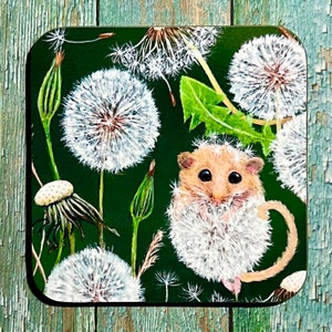 May include: Square coaster with a dark green background featuring white dandelions and a small, light brown hamster. The hamster is surrounded by dandelion fluff. Green leaves and stems are also visible.