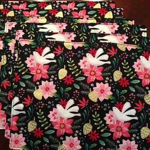 Christmas placemats. Poinsettia and Dove Placemats. Pink Pointsettias and white doves on a black background. Metallic accents.  Modern