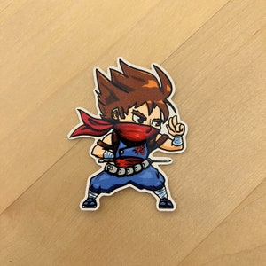 May include: A cartoon illustration of a ninja with brown hair, a red bandana, and a blue and white outfit. The ninja is holding a sword and has a determined expression on their face.