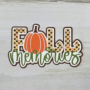May include: Fall Memories sign with a brown and yellow patterned background and a green pumpkin silhouette.