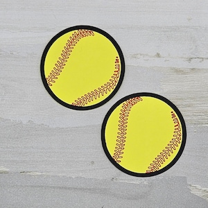 May include: Two yellow and red softball stickers with black outlines.