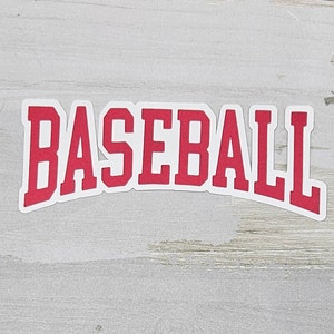 May include: Red and white baseball word graphic on a light gray wood background.