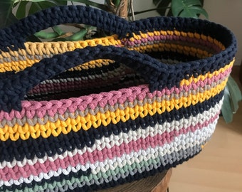 A large beach bag, an oval colorful hand basket.