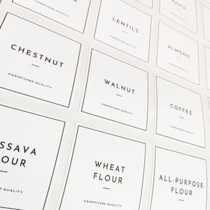 Könnte beinhalten: Weiße quadratische Etiketten mit schwarzen Rändern und Text. Die Etiketten lauten: Kastanie, Walnuss, Weizenmehl, Allzweckmehl, Kaffee, Mandel, Linsen, Tapiokamehl und Pasta. Jedes Etikett enthält den Satz "Handverlesene Qualität".