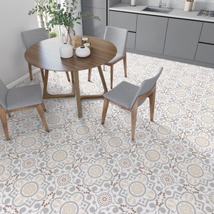 Könnte beinhalten: Ein Esszimmer mit einem runden Holztisch und vier grauen Stühlen. Der Boden ist mit einem floralen Muster in Grau, Beige und Braun gefliest. Der Tisch ist mit Vasen und Kerzen dekoriert. Der Raum hat ein modernes, neutrales Farbschema.