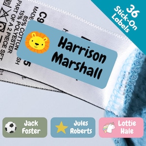 May include: A light blue rectangular stick-on label featuring a cartoon lion face and the text Harrison Marshall, applied to a white clothing tag. Additional labels include a green one with a soccer ball, a blue one with a star, and a pink one with a unicorn.