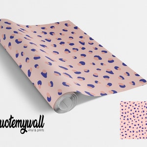 May include: A roll of pink and blue leopard print wallpaper with the text "quote my wall vinyl & prints" on the bottom left corner.