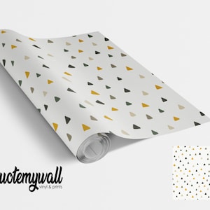 May include: A roll of white wallpaper with a repeating pattern of small yellow, green, and brown triangles. The wallpaper is rolled up and the end of the roll is visible. The text "quotemywall vinyl & prints" is printed on the bottom of the image.