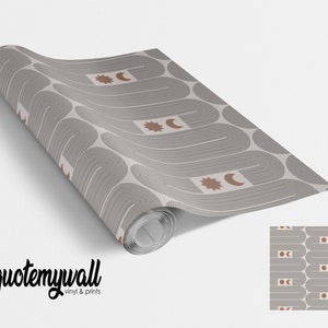 Puede incluir: Un rollo de papel pintado con un patr&oacute;n repetitivo de l&iacute;neas curvas grises y marrones, con formas de sol y luna. La marca "quotemywall" est&aacute; impresa en escritura negra en la parte inferior.