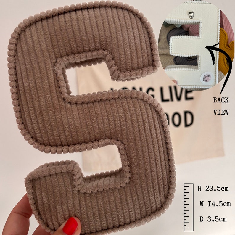 May include: A brown corduroy letter S with a white backing. The letter is 23.5 inches tall, 14.5 inches wide, and 3.5 inches deep. The back of the letter has a loop for hanging.